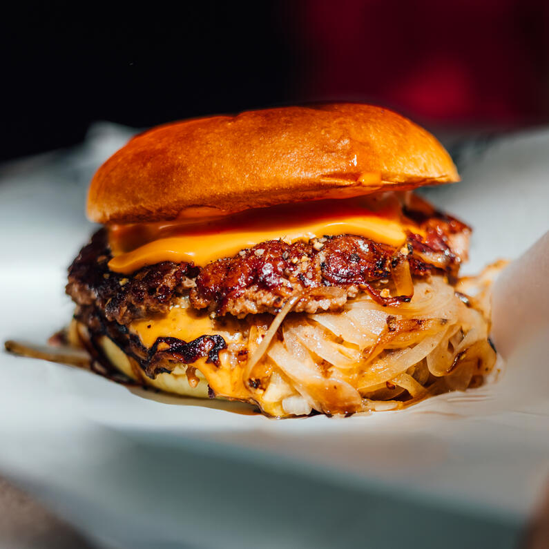 Oklahoma Smashed Burger Oklahoma Smashburger mit zwei knusprig gesmashten Beef Patties, geschmolzenem Käse und gebratenen Zwiebeln bei der Probierbude Hannover.